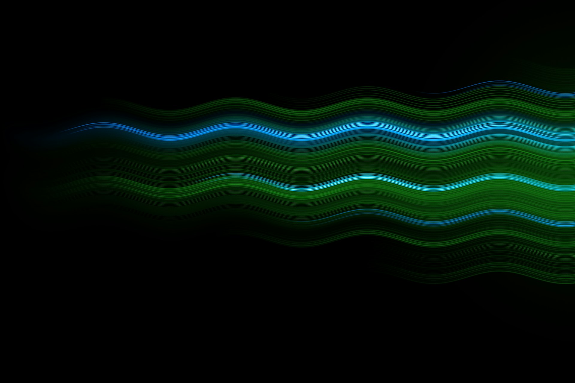 Long-exposure light trails forming smooth green and blue waves across a black field